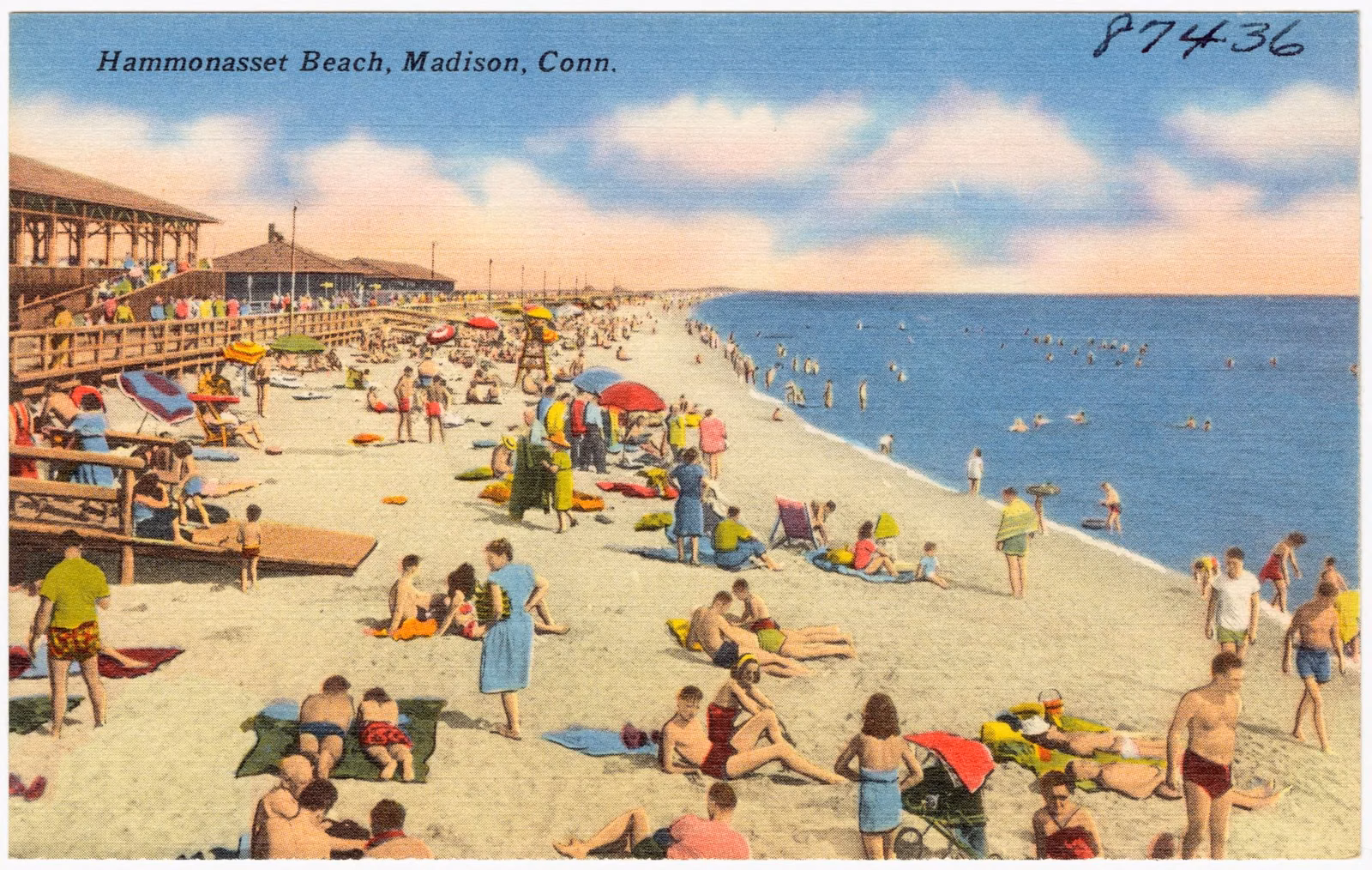 Mid-1900s postcard of a crowded Hammonasset Beach with the old wooden boardwalk and pavilion